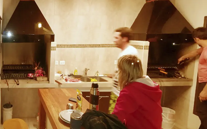Huéspedes cocinando en el quincho cubierto de las cabañas Posada El Barranco en El Chaltén